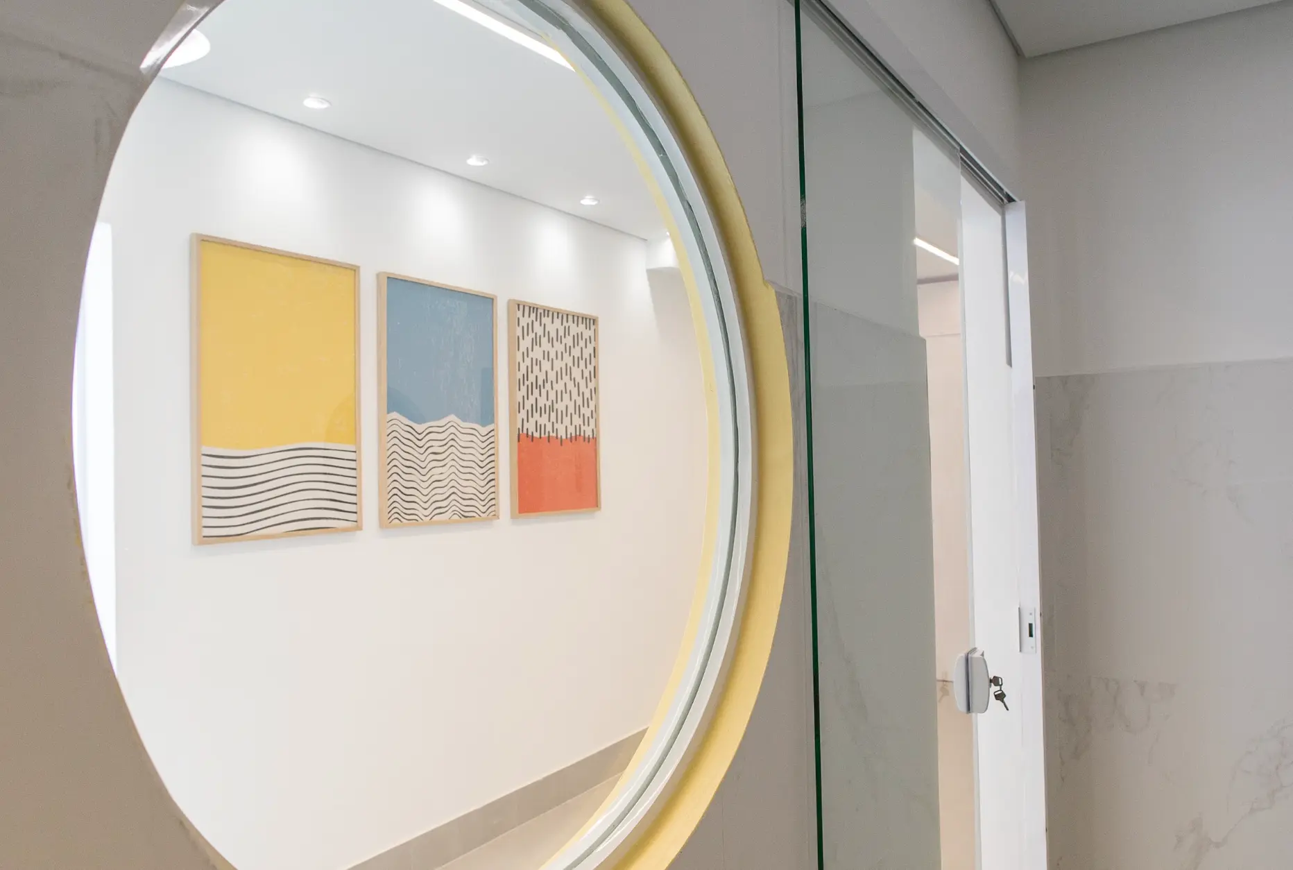Corredor decorado com espelho redondo na unidade Rio Tavares